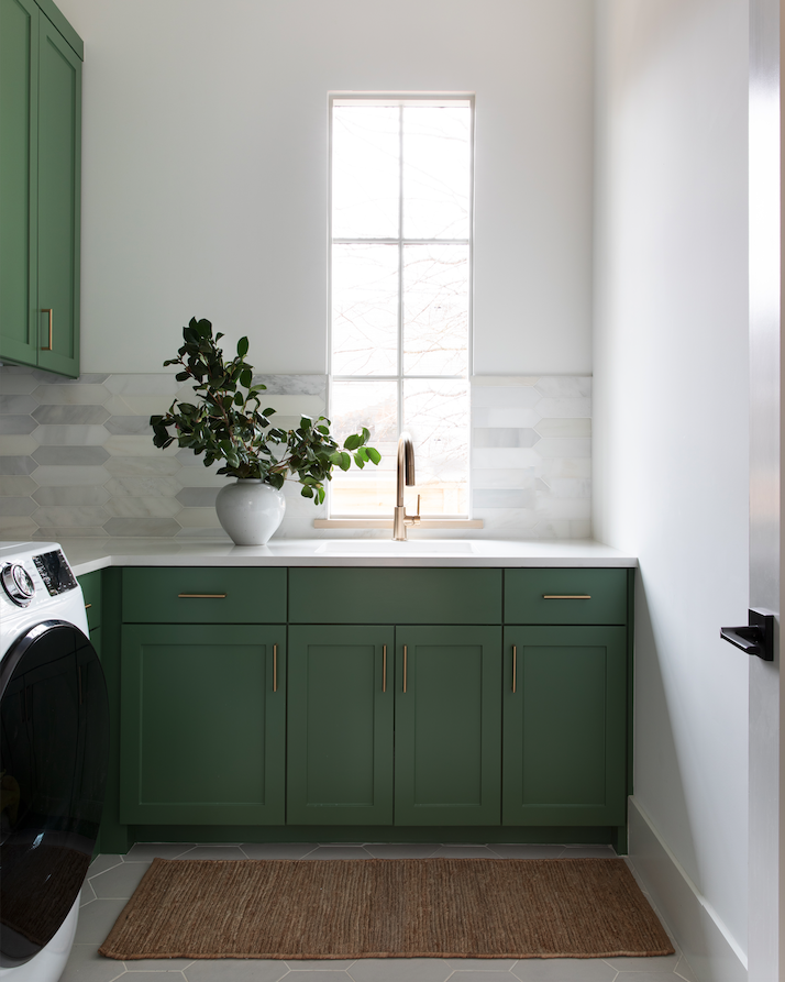 a laundry room with green cabinets