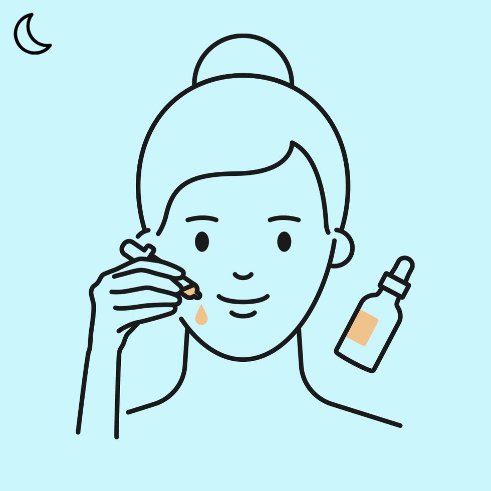 woman applying face oil at night