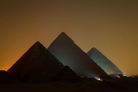 Tegen de stadslichten van Caro steken de Piramiden van Gizeh als indrukwekkende silhouetten af