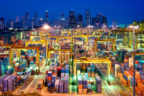 In de haven van Singapore worden scheepcontainers door schijnwerpers verlicht