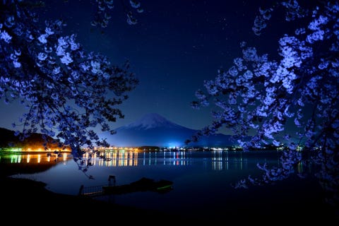Lichten markeren de oever van het Kawaguchimeer met op de achtergrond de berg Fuji