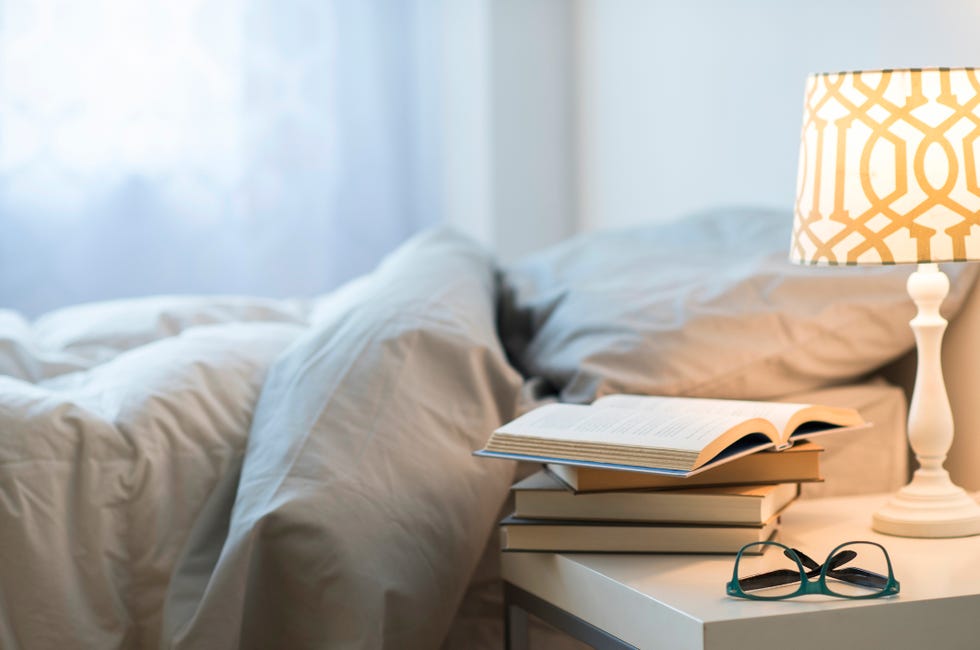a lamp and a bed with books