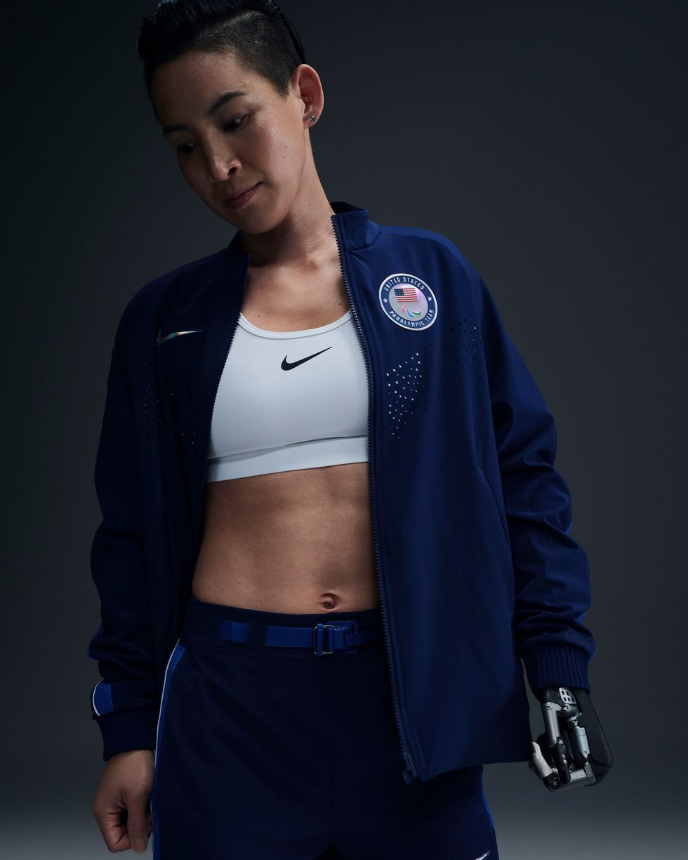 a person in a blue jacket and track pants
