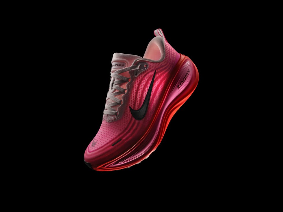 a cushioned nike running shoe illuminated against a pink background