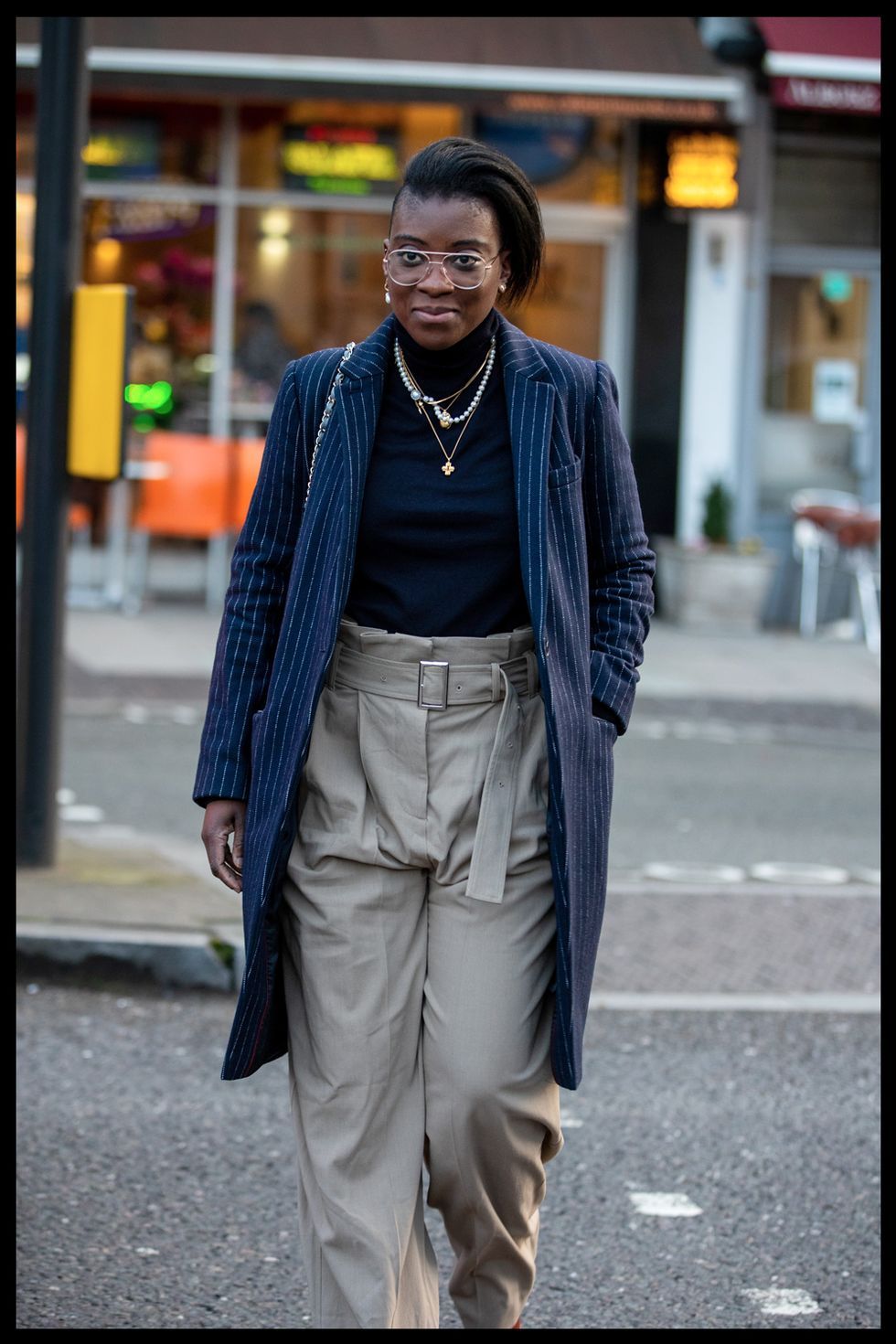 nikki ogunnaike wears plaid trousers and a longline coat to new york fashion week