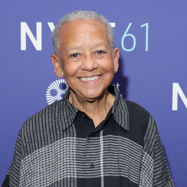 nikki giovanni smiles at the camera, she wears a black and grey patterned collared shirt