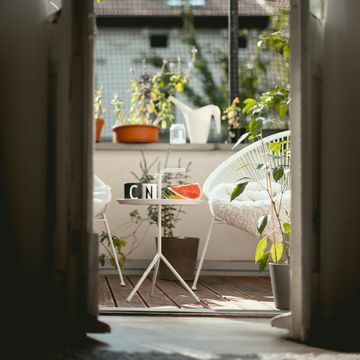 a window with a table and chairs and a planter with flowers