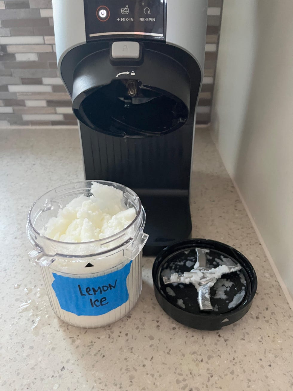 ninja creami pint and lid and machine with lemon ice inside
