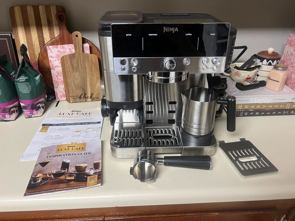 an espresso machine on a kitchen counter along with its accessories