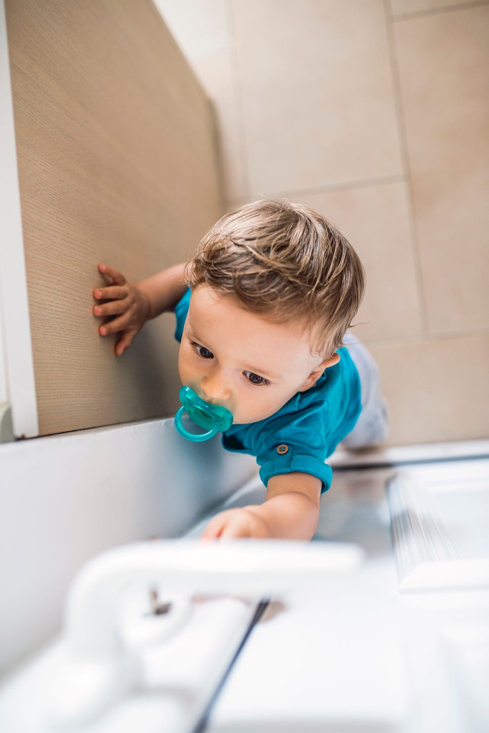 un niño pequeño intenta abrir la puerta exterior de una casa
