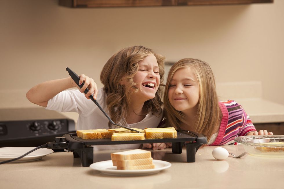 dos niñas preparan unas tostadas