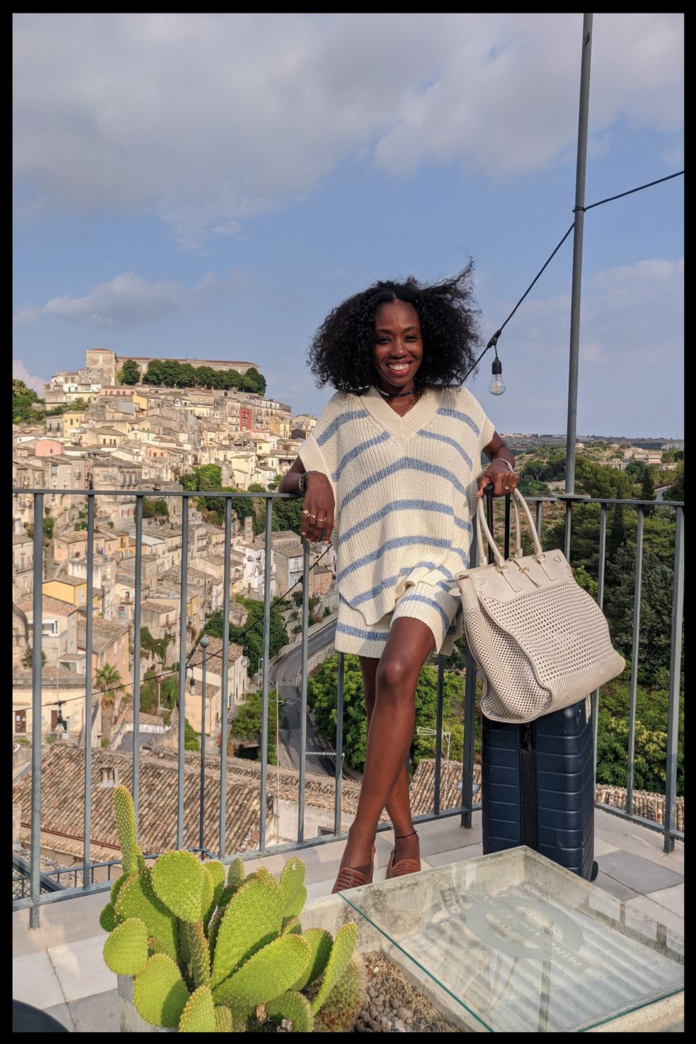 nneya richards carries a ferregamo bag and away suitcase in italy