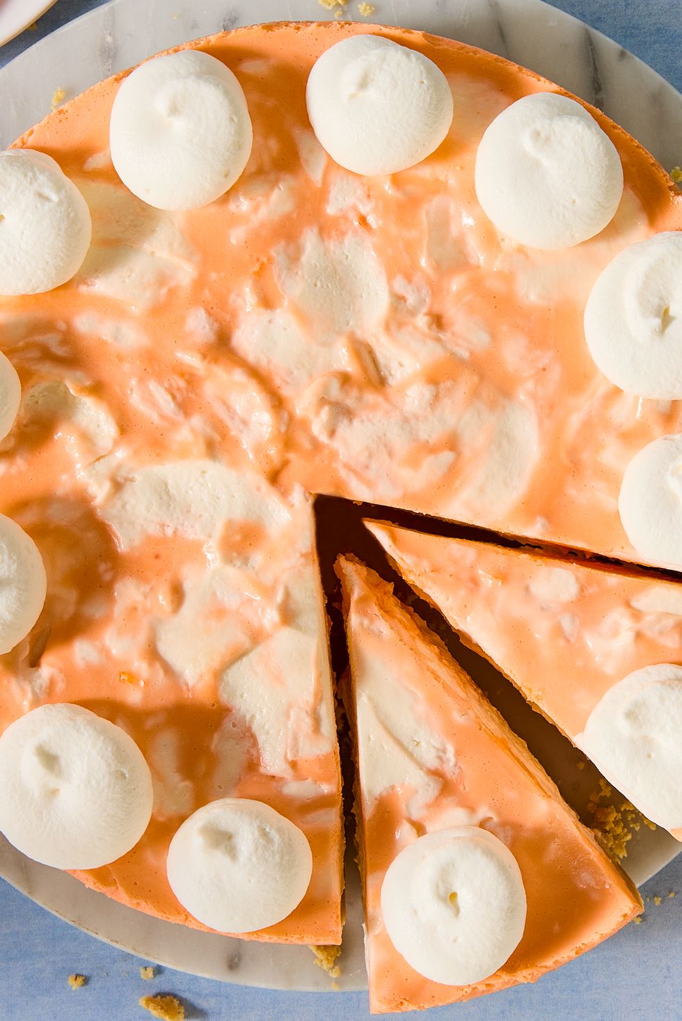 no bake creamsicle cheesecake with dollops of whipped cream and a graham cracker crust