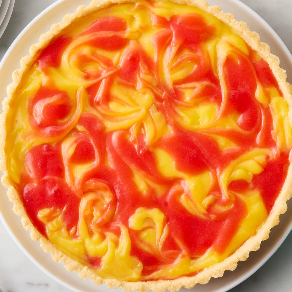 a tart made with cookie crust and a filling of lemon and strawberry curds swirled together. served with whipped cream on the side