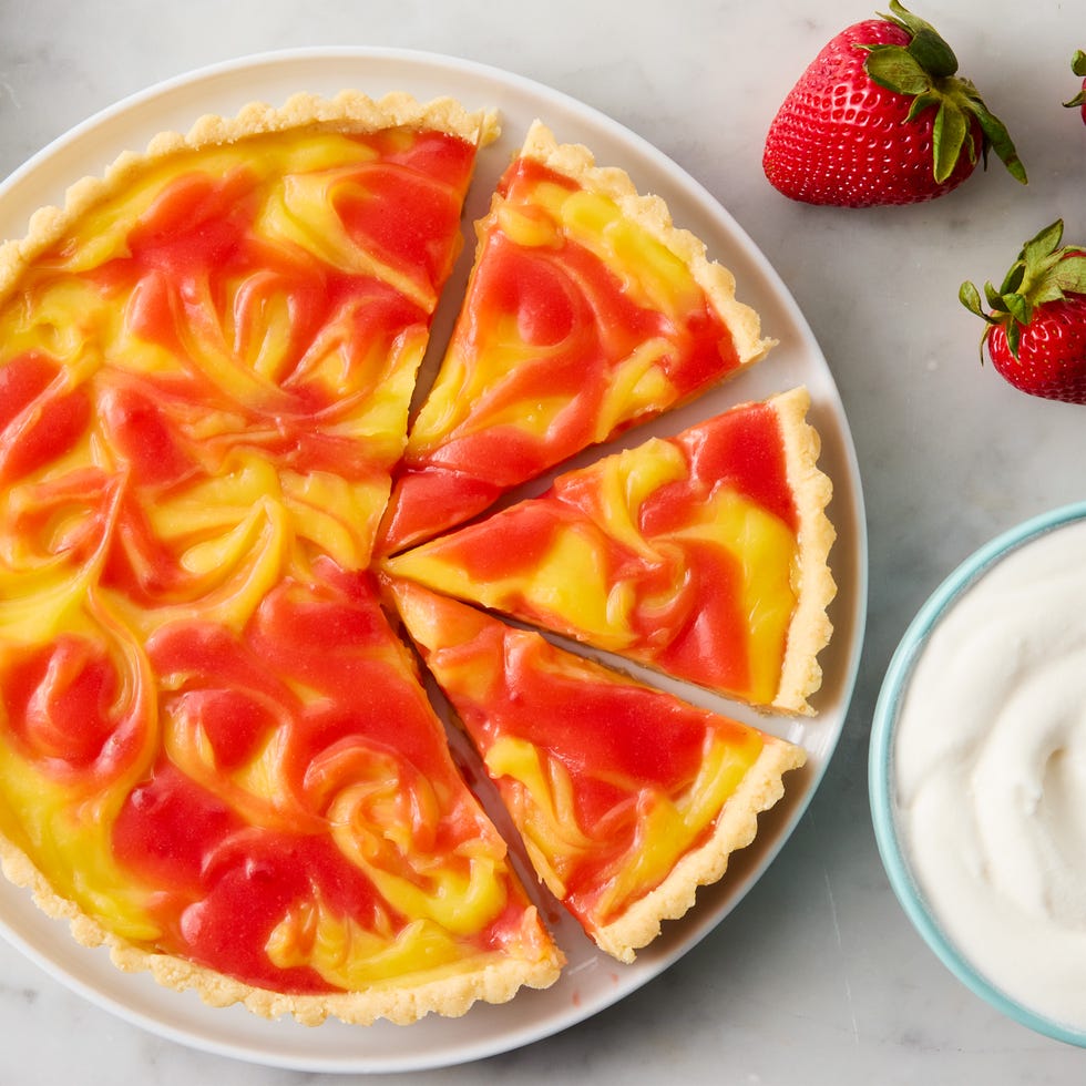 a tart made with cookie crust and a filling of lemon and strawberry curds swirled together. served with whipped cream on the side