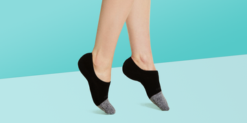 person wearing a black and grey pair of no show socks on a light blue background, good housekeeping best no show socks