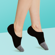 person wearing a black and grey pair of no show socks on a light blue background, good housekeeping best no show socks