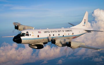 white airplane with black nose cone and united states dept of commerce on the side