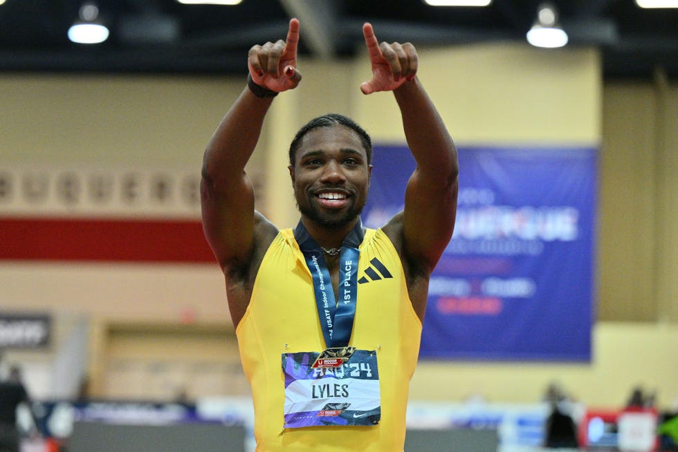 noah lyles smiling with a medal around his neck and pointing upward with both of his hands