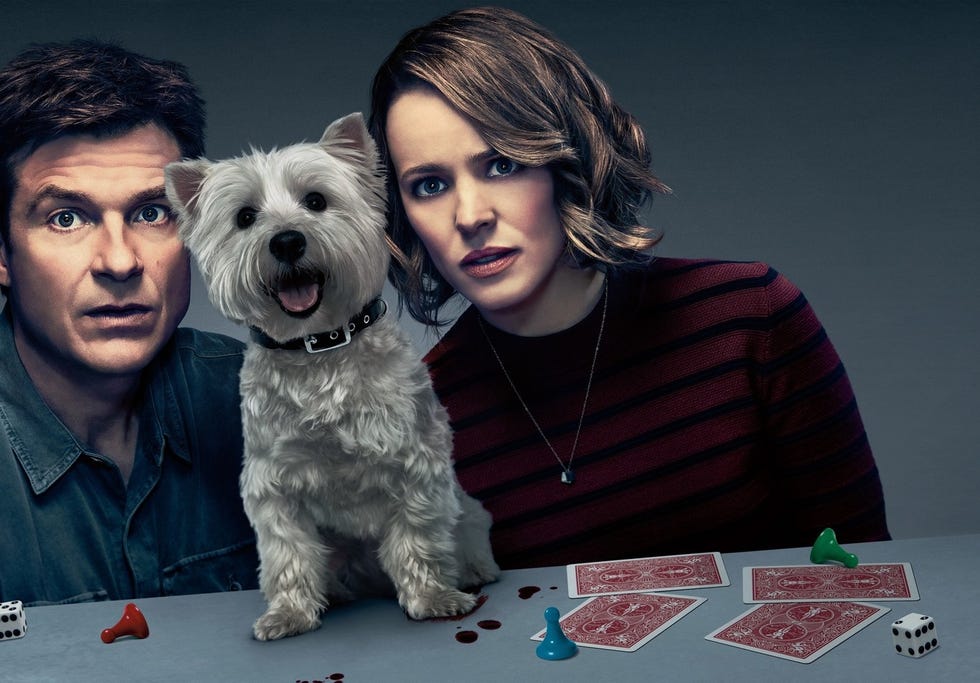 una pareja con su perro y unas cartas en la película noche de juegos