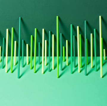 uneven green plastic pipes leaning on green colored background front view
