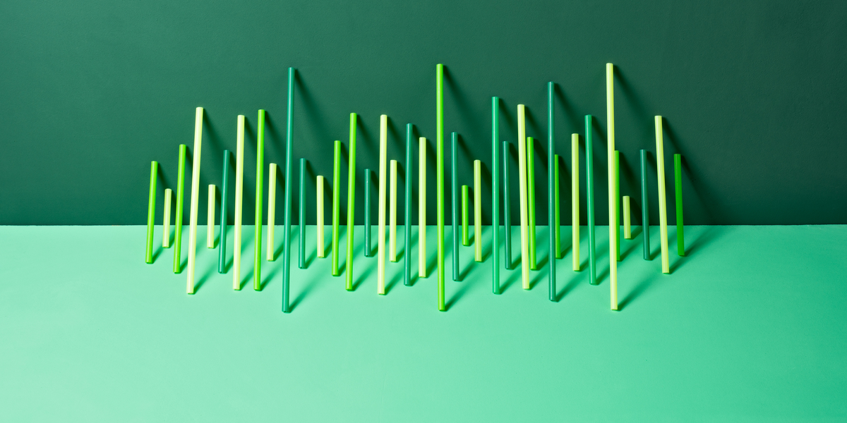 uneven green plastic pipes leaning on green colored background front view