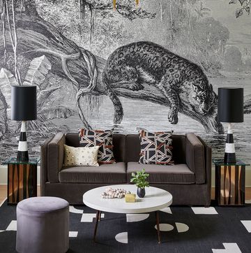 velvet sofa with large leopard mural behind it