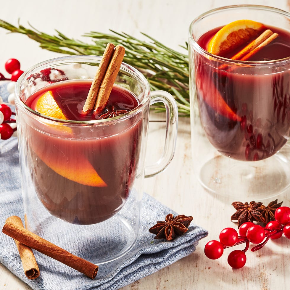 nonalcoholic mulled wine in a glass mug garnished with cinnamon sticks, star anise, and an orange wedge
