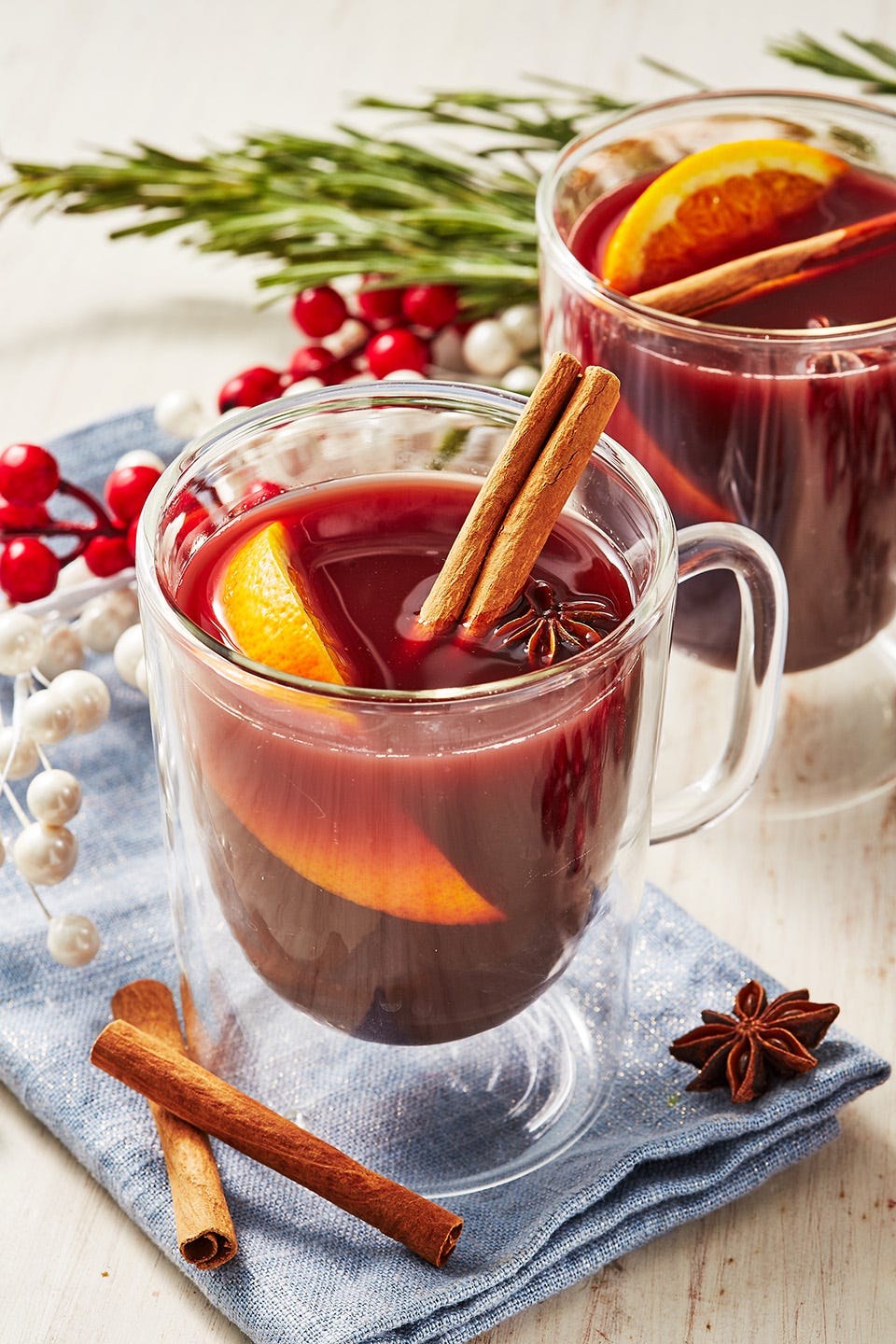 non alcoholic mulled wine in a glass with an orange wedge, cinnamon stick, and star anise