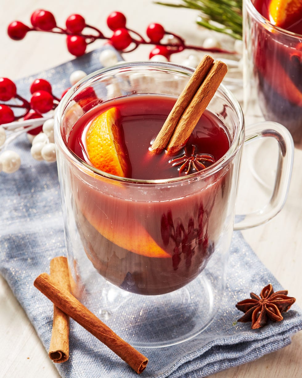 nonalcoholic mulled wine in a glass mug garnished with cinnamon sticks, star anise, and an orange wedge