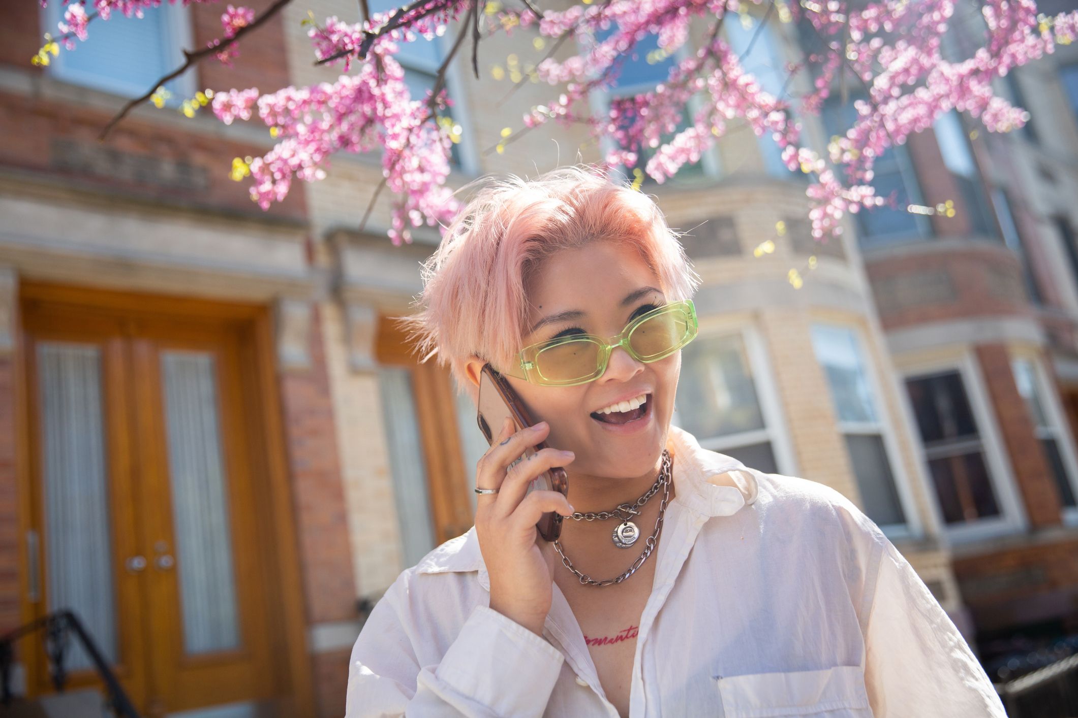 non binary queer person calling on the phone and smiling