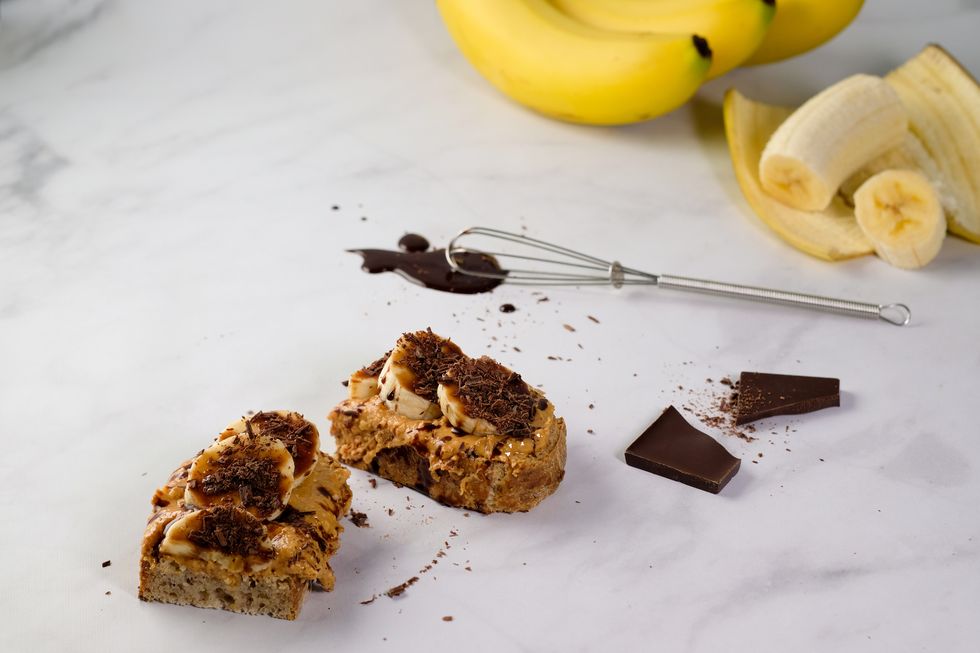 nut butter on toast with bananas and chocolate in a kitchen setting