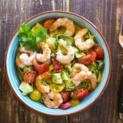 noodle salad with avocado, tomato and shrimps in bowl on wood