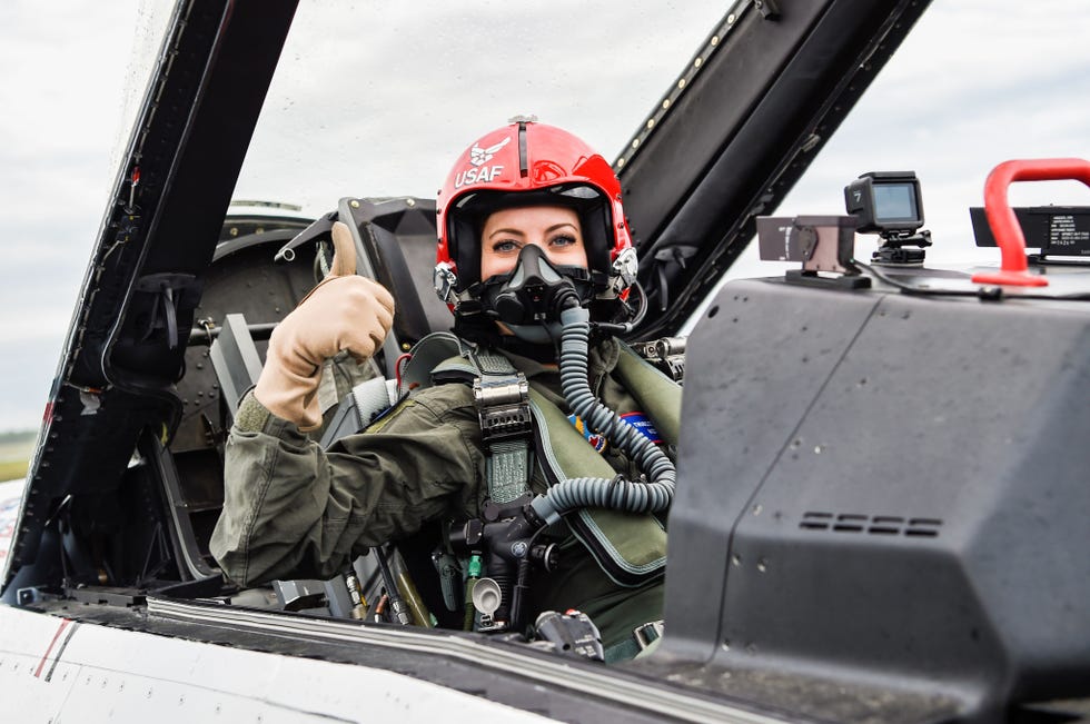 pilot in flight gear giving a thumbs up from an aircraft cockpit