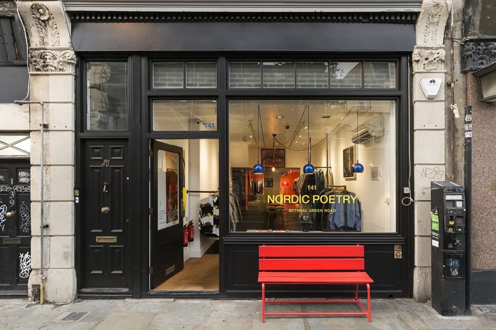 a store front with a red bench
