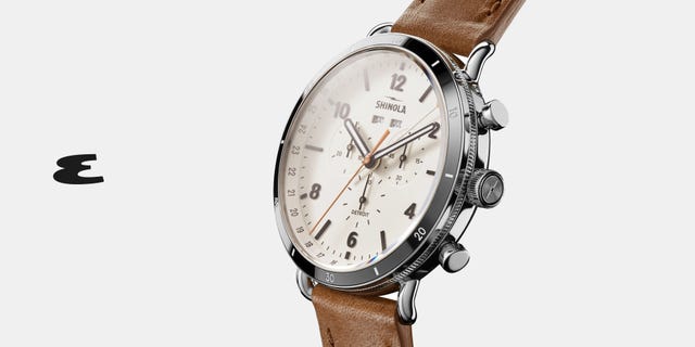 a silver watch with brown leather strap