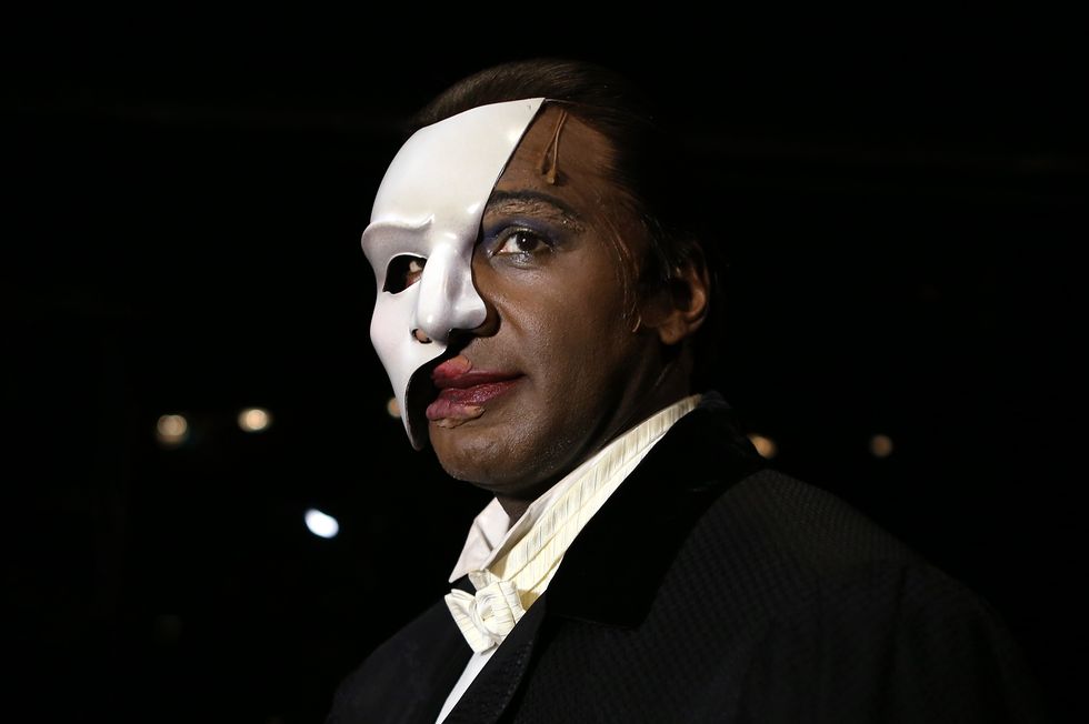 norm lewis wearing a black tuxedo and wearing a white face mask