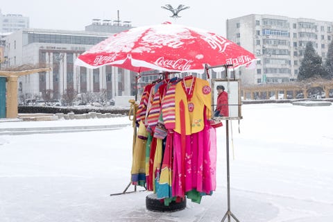 In de stad Dandong steken traditionele Koreaanse kledingstukken kleurrijk af tegen de sneeuw