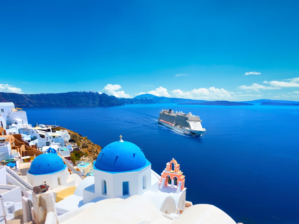 panoramic view with greek orthodox church with blue domes and sea in oia in santorini, greece