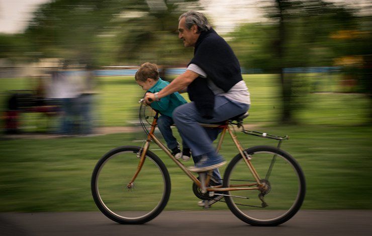 An older and younger cyclist. 