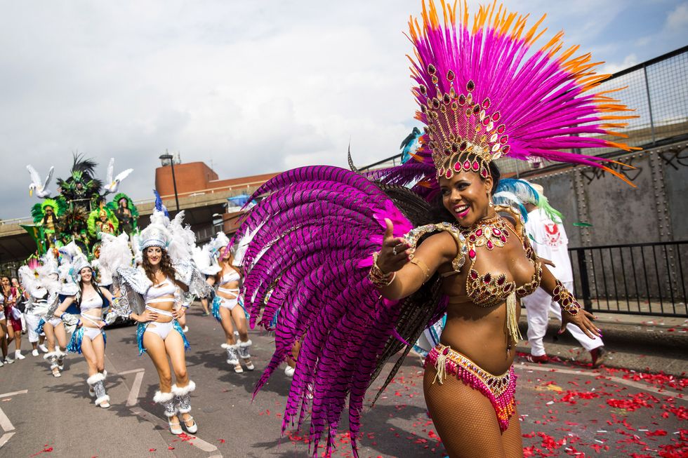 london, england   august 29 performers take part in the notting hill carnival on august 29, 2016 in london, england the notting hill carnival, which has taken place annually since 1964, is expected to attract over a million people the two day event, started by members of the afro caribbean community, sees costumed performers take to the streets in a parade and dozens of sound systems set up around the notting hill streets photo by jack taylorgetty images