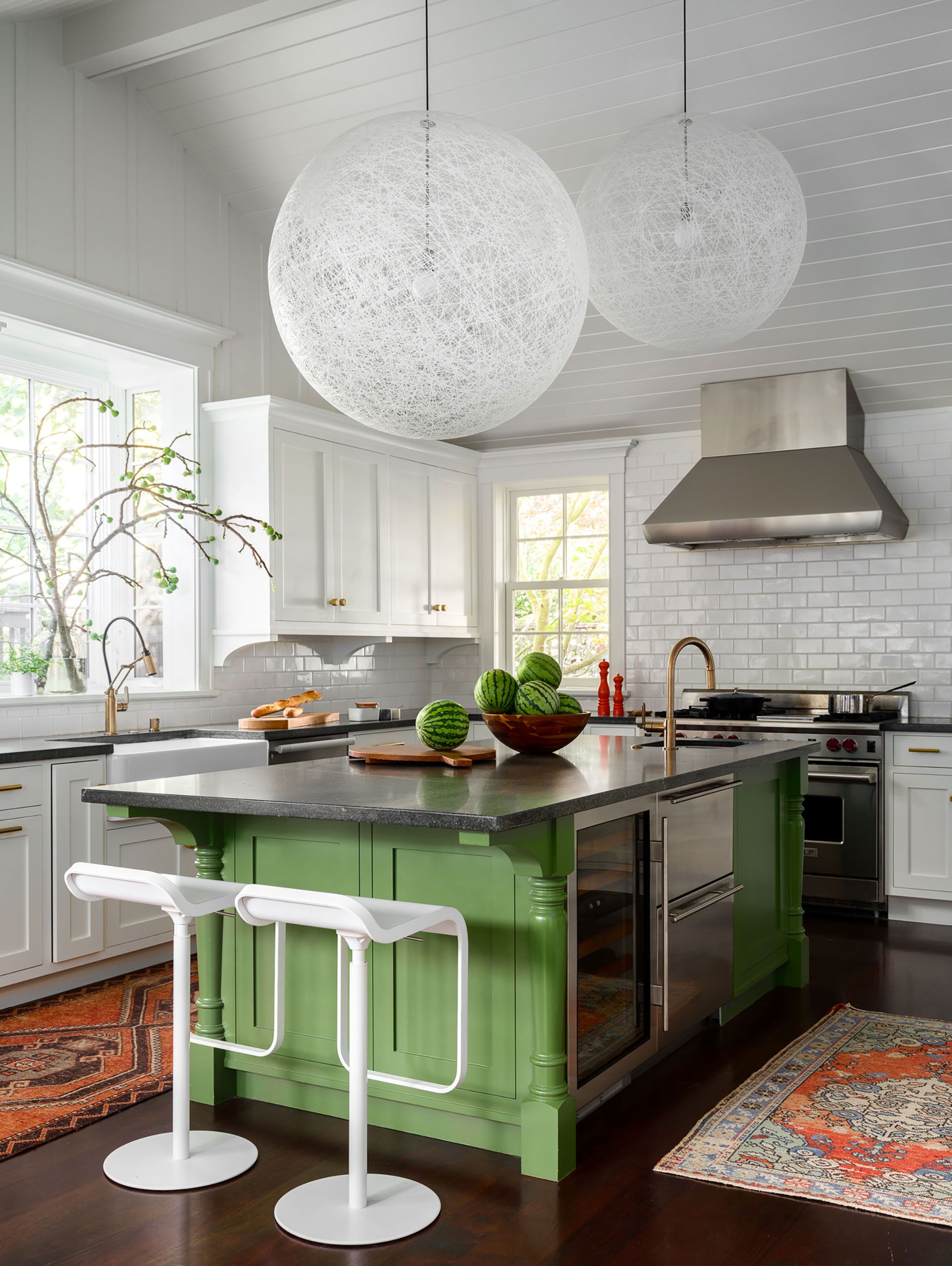 A vintage green kitchen with an island featuring white brick