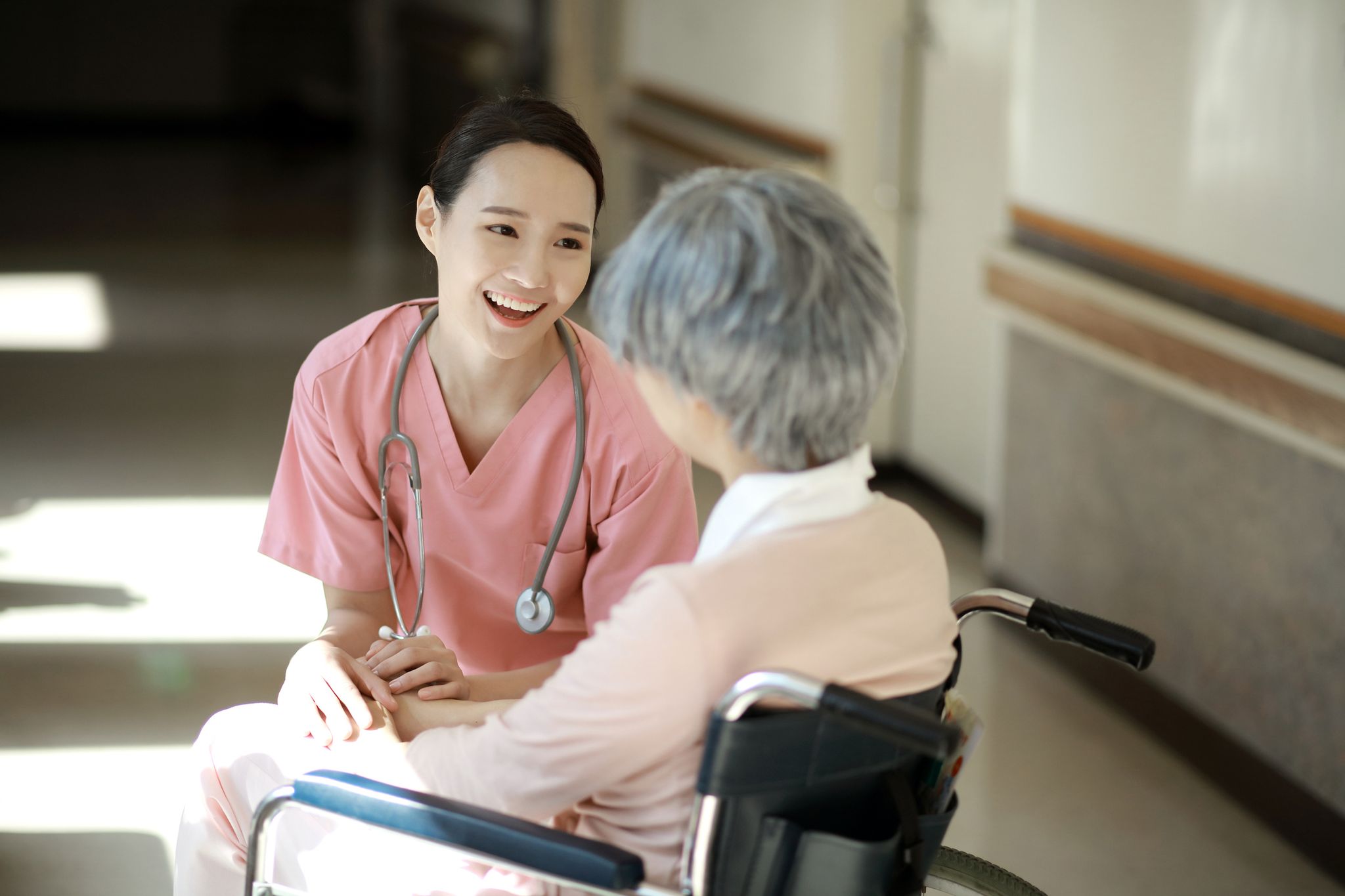 nurse caring for senior woman in wheelchair