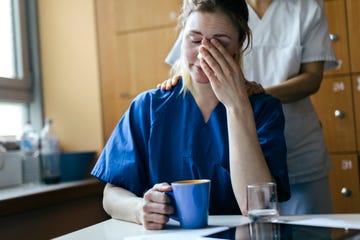 nurse consoling young female doctor