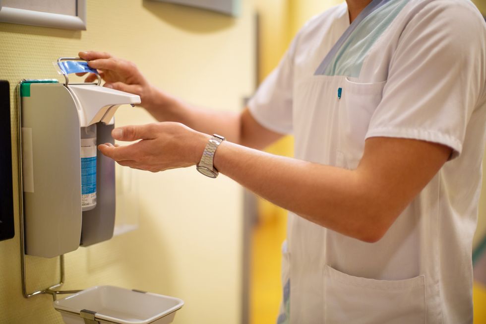 Nurse using anti-bacterial hand sanitizer in clinic