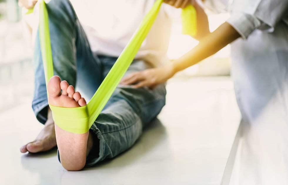 doctor examining womans feet in office