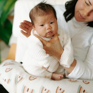 mom and baby sitting in chair with nursing pillow