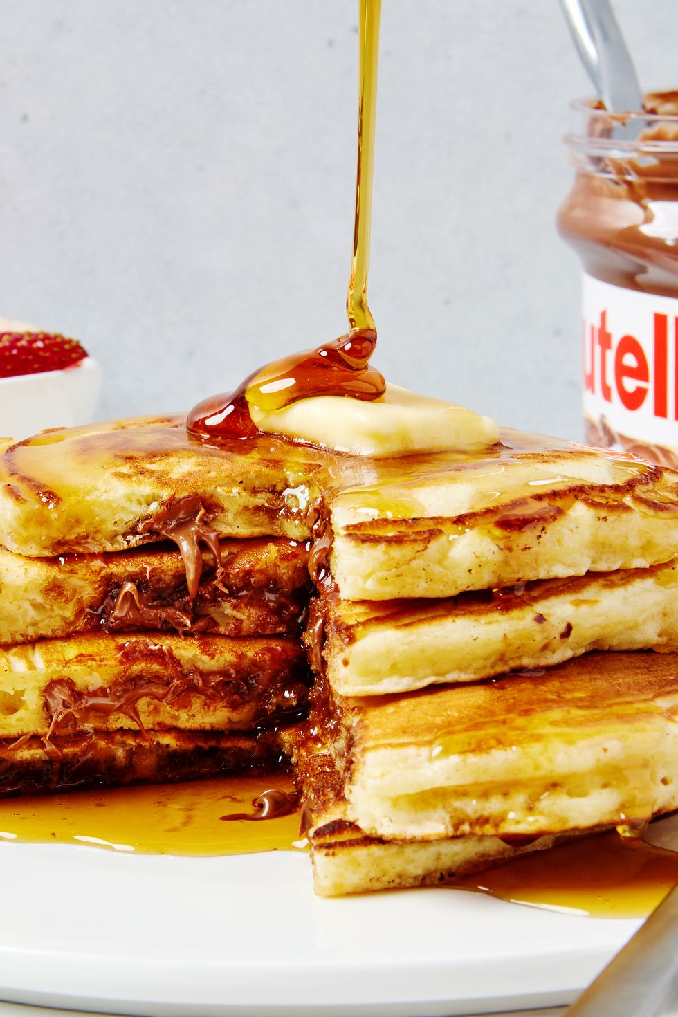 triple stack of pancakes stuffed with nutella and topped with butter and syrup