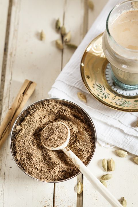 cardamom ground in bowl with chai tea in background