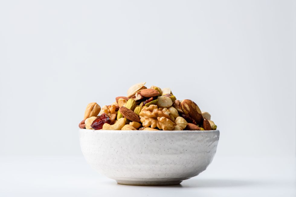 mix nuts and dry fruits in a bowl with white background